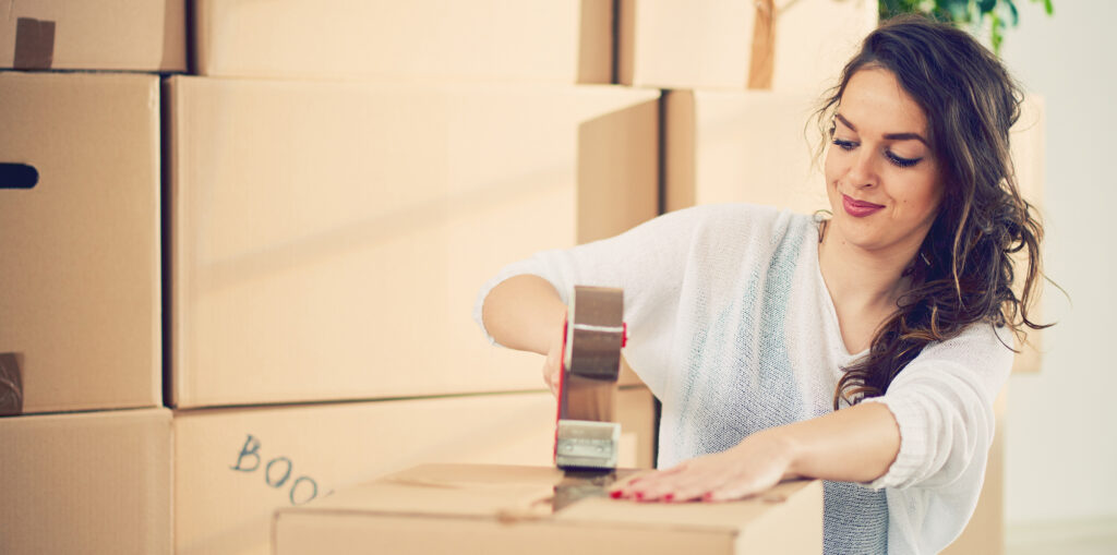 A woman taping boxes